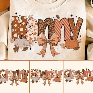 May include: A white sweatshirt with a brown, orange, and white patterned design that says "Mommy" with a bow and pumpkins.
