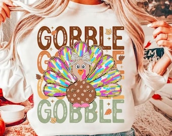 May include: White sweatshirt with a colorful turkey graphic and the text "Gobble Gobble Gobble" in a vintage style font.