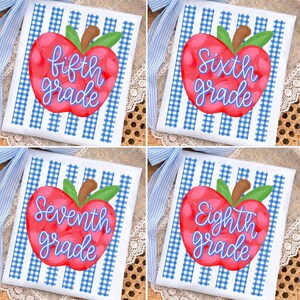 May include: Four white fabric squares featuring a blue gingham pattern and a red apple graphic. Each apple displays blue cursive text reading fifth grade, sixth grade, seventh grade, or eighth grade, with a green leaf and brown stem.