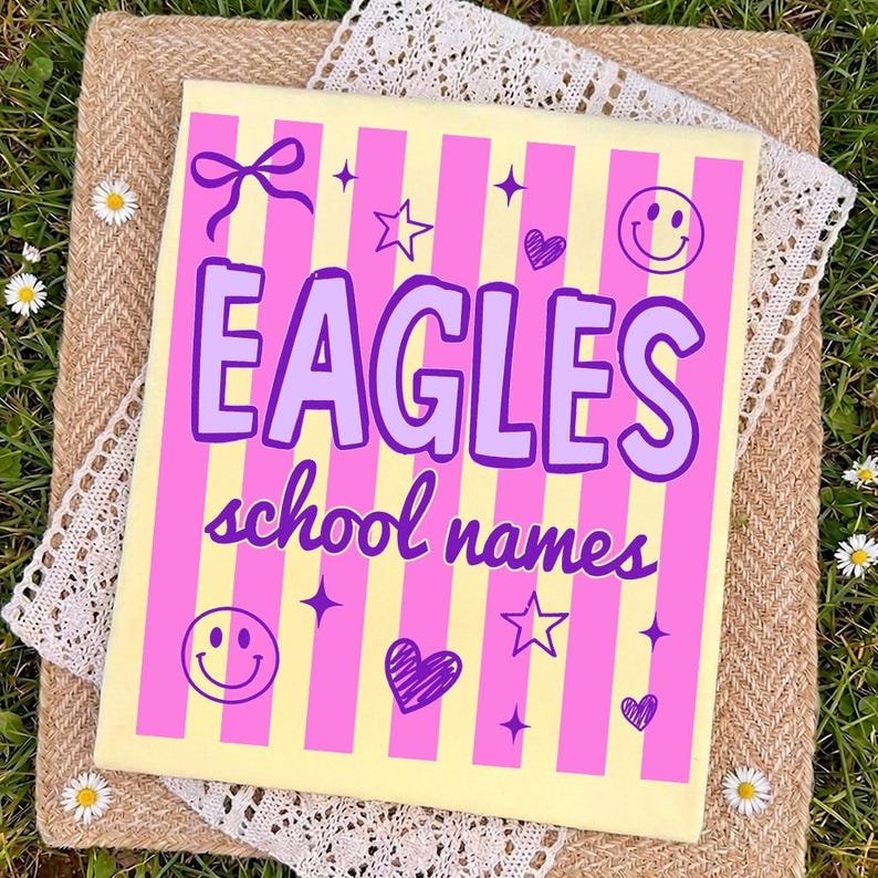 Op de afbeelding: Een rechthoekig canvas met een geel en roze gestreepte achtergrond. Het canvas toont het woord "EAGLES" in paars, samen met de woorden "school names". Het ontwerp bevat harten, sterren, een strik en smiley gezichten.