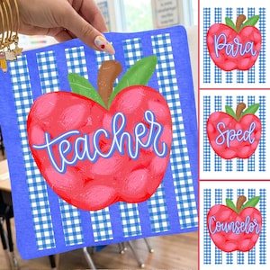 May include: A blue and white gingham-patterned sign featuring a large red apple with the word "teacher" in blue script. Additional apple-shaped signs with the words "Para", "Sped", and "Counselor" are also visible.