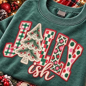 May include: A dark green crewneck sweatshirt featuring the word JOLLY in large block letters with red and green plaid, floral, and polka dot patterns. A white embroidered Christmas tree with red beads replaces the letter O. The word ish is written below in red script.