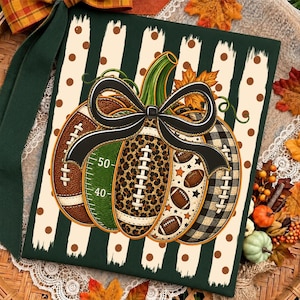 May include: A square decorative sign featuring a central pumpkin graphic composed of football-themed segments, including leopard print, brown leather, green field markings with numbers 40 and 50, and black plaid, topped with a large black bow.
