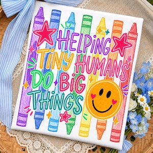 May include: A white rectangular canvas featuring a colorful illustration of vertical crayons in purple, blue, green, yellow, orange, and red. The text reads HELPING TINY HUMANS DO BIG THINGS in multi-colored letters with a yellow smiley face icon.