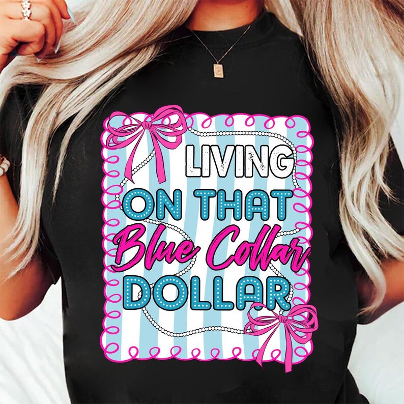 May include: Black t-shirt with a graphic that reads "LIVING ON THAT Blue Collar DOLLAR." The design features a light blue and white striped background, pink bows, and white pearl-like accents. The text is in white and pink.
