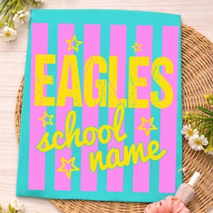 May include: A teal and pink striped design with the word "EAGLES" in yellow block letters. Below, the words "school name" are written in a yellow script font, with yellow star accents.