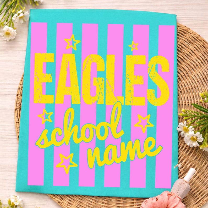 May include: A teal and pink striped design with the word "EAGLES" in yellow block letters. Below, the words "school name" are written in a yellow script font, with yellow star accents.