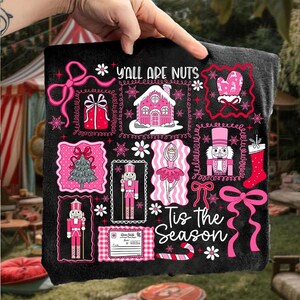May include: Black decorative throw blanket with pink and white Christmas-themed illustrations. The blanket features images of a gingerbread house, nutcrackers, a Christmas tree, and the text "Y'all Are Nuts" and "Tis the Season".