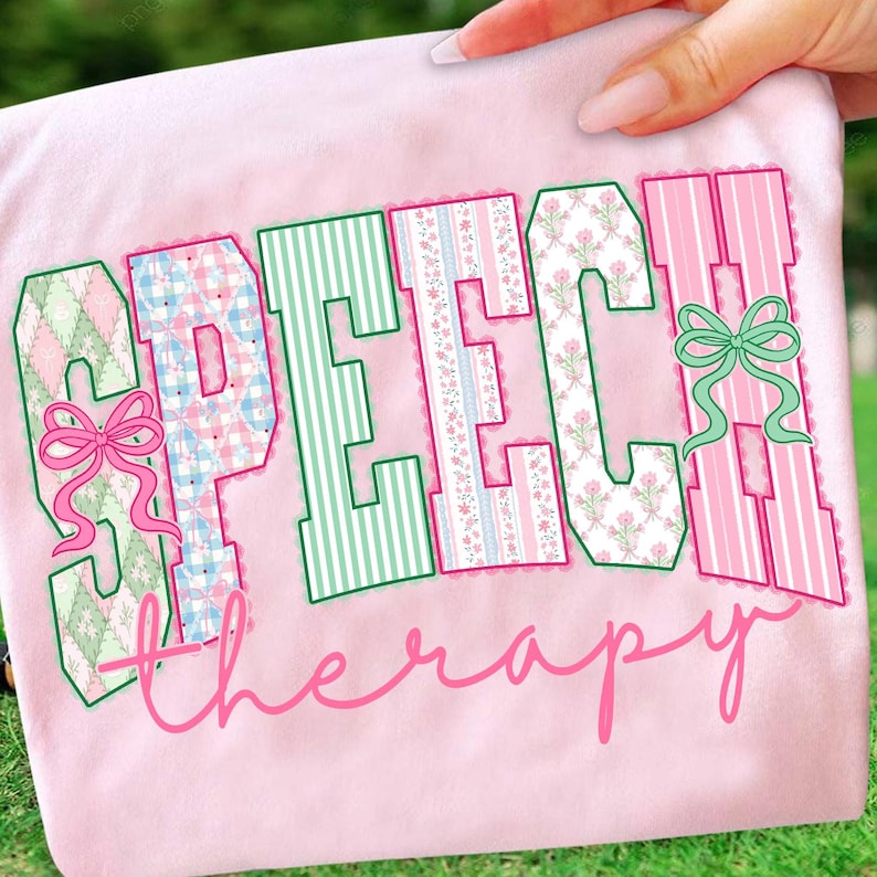 Puede incluir: Una camiseta rosa claro con las palabras "SPEECH THERAPY" en una fuente decorativa. Las letras est&aacute;n delineadas en verde y rellenas con varios patrones, incluyendo rayas, estampados florales y cuadros. Lazos rosas acent&uacute;an el dise&ntilde;o.