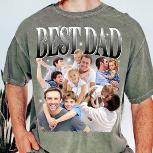 May include: A gray t-shirt with the words "BEST DAD" in a silver, outlined font. The shirt features a collage of photos of fathers and children. The overall theme is family and fatherhood.