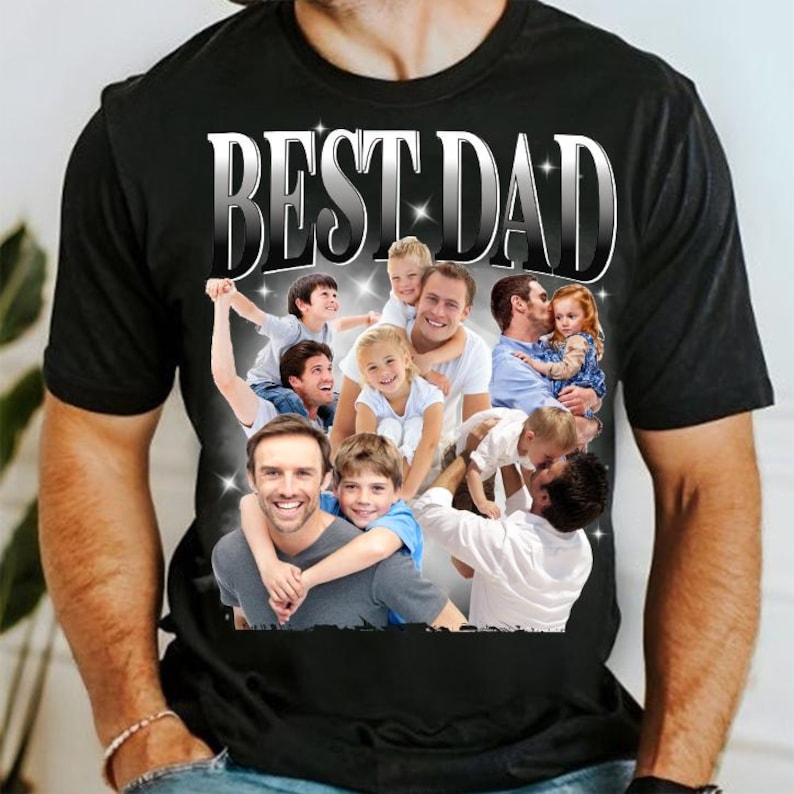 May include: Black t-shirt with a graphic that says "BEST DAD" in silver lettering. The graphic features a collage of photos of fathers and children. The shirt is made of a soft material.