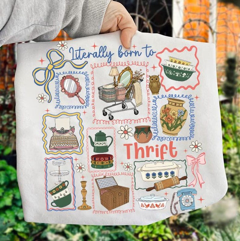 May include: A white tote bag featuring a colorful illustration of various vintage items, including a shopping cart, mirror, owl, and teapot. The words "Literally born to Thrift" are printed on the bag in a whimsical font.