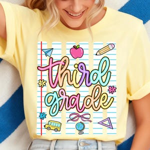 Peut inclure: T-shirt jaune clair avec un motif color&eacute; "Third Grade". Le design comprend un avion en papier, une pomme, un crayon, des fleurs, un bus scolaire, un n&oelig;ud, un globe et un triangle. Le texte est dans une police cursive ludique.
