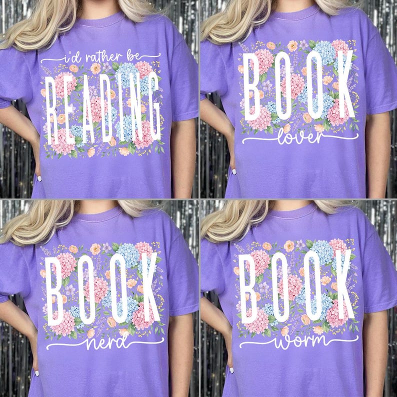 May include: Four lavender t-shirts with floral designs and white text. One shirt says "I'd rather be READING", another says "BOOK lover", a third says "BOOK nerd", and the last says "BOOK worm". The shirts have short sleeves.
