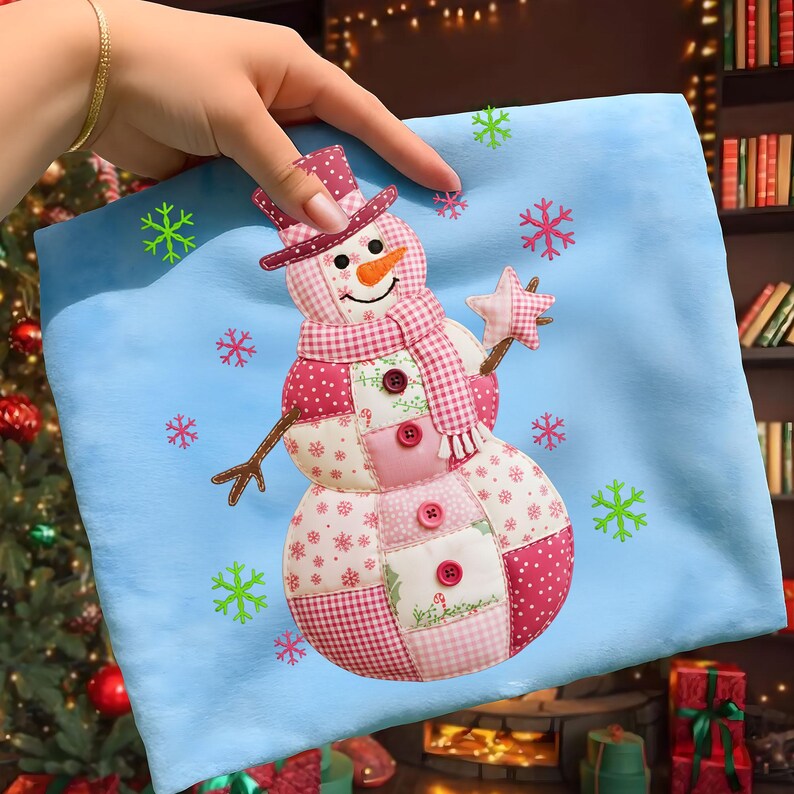 May include: A light blue cushion with a patchwork snowman design. The snowman has a carrot nose, a pink and white patterned hat and scarf, and holds a star. Decorative snowflakes surround the snowman. A festive holiday decoration.