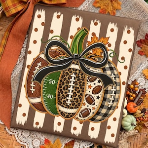 May include: A rectangular canvas print featuring a central pumpkin illustration decorated with a black bow. The pumpkin segments display football-themed patterns including brown leather, green yard lines, leopard print, and black plaid.