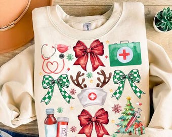 Puede incluir: Una sudadera beige con un diseño navideño con lazos rojos y verdes, un gorro de Papá Noel rojo y blanco, un botiquín verde con una cruz roja y un árbol de Navidad verde con una estrella roja en la parte superior.