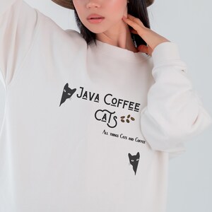 May include: White sweatshirt with a black cat graphic and the text "Java Coffee Cats" and "All things cats and coffee".