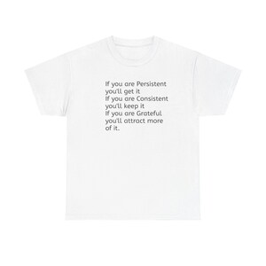 Puede incluir: Camiseta blanca con texto negro. El texto dice: "Si eres persistente, lo conseguirás. Si eres constante, lo mantendrás. Si eres agradecido, atraerás más de ello."