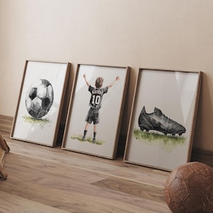 Peut inclure: Trois illustrations &agrave; l'aquarelle encadr&eacute;es d'un joueur de football, d'un ballon de football et d'un crampon de football. Le joueur porte un maillot noir avec le num&eacute;ro 10 au dos. Le ballon de football est noir et blanc. Le crampon est noir et a une semelle blanche.
