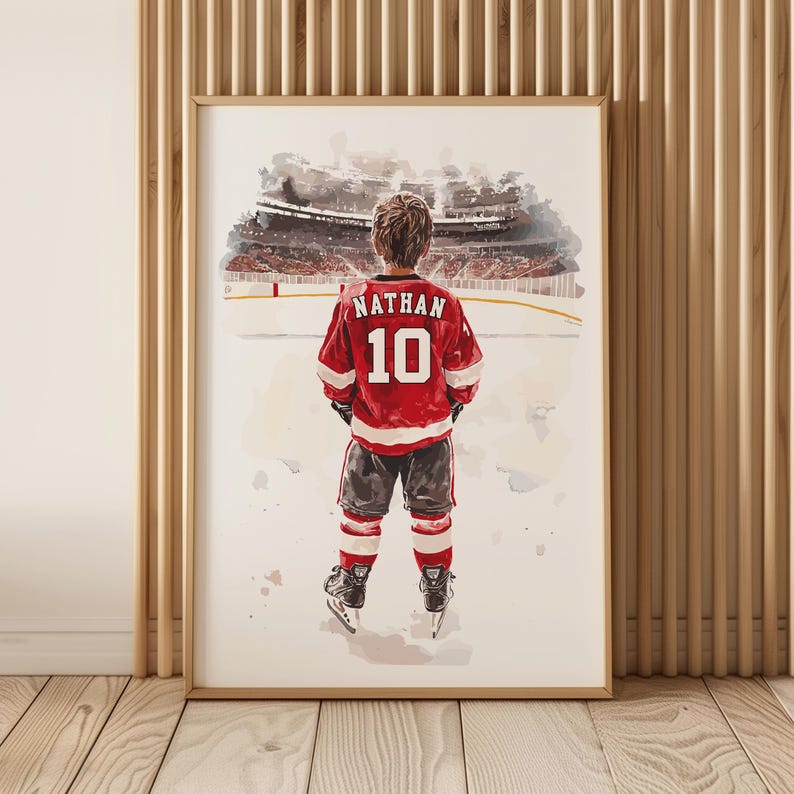 May include: A watercolor painting of a young hockey player wearing a red jersey with the name "Nathan" and the number "10" on the back. The player is standing on the ice in front of a blurred background of a hockey arena.