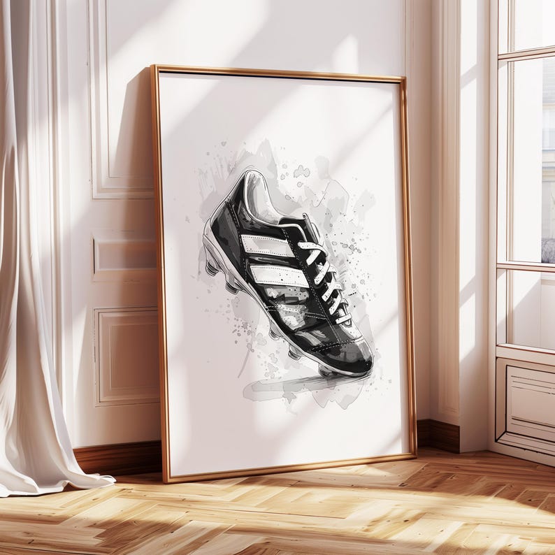May include: Black and white watercolor illustration of a soccer cleat with white stripes. The cleat is on a white background with gray watercolor splatters.