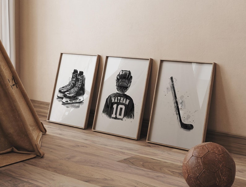 May include: Three framed black and white illustrations of hockey equipment. The first illustration shows a pair of hockey skates. The second illustration shows a hockey player wearing a jersey with the name "Nathan" and the number "10". The third illustration shows a hockey stick.