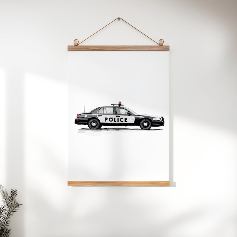 May include: Black and white police car illustration with the word "POLICE" on the side. The car has a red light on top and is hanging from a wooden frame. The artwork is displayed on a white wall.