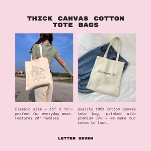 Pode incluir: Duas sacolas tote de lona de algod&atilde;o grossa. A sacola &agrave; esquerda tem um desenho de uma garrafa de vinho, copos e uma baguette. A sacola &agrave; direita tem o texto "It's no use, Jo!" impresso nela. Ambas as sacolas t&ecirc;m al&ccedil;as de 50 cm.