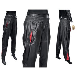 May include: Black leather pants with red zipper accents. The pants have a drawstring waistband and a relaxed fit.