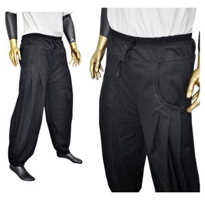 May include: Black pants with a drawstring waist and a single pocket on the right side. The pants are made of a soft, comfortable fabric and have a relaxed fit.