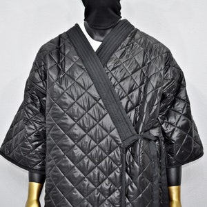 May include: A black quilted robe with a tie closure. The robe has a diamond pattern and is made of a shiny material.