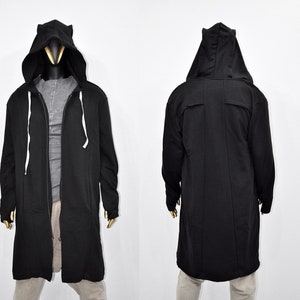 May include: A long black hooded sweatshirt with a zipper closure. The hood has a pointed shape at the top.