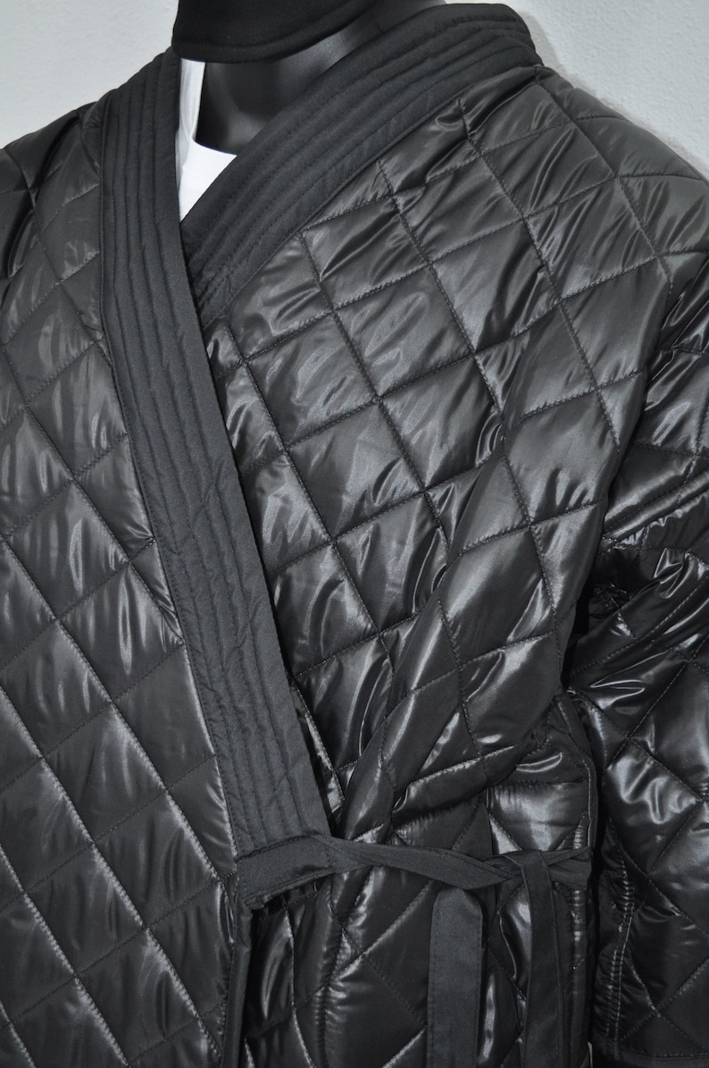 May include: A black quilted robe with a long sash tie. The robe has a diamond pattern and a satin-like sheen.