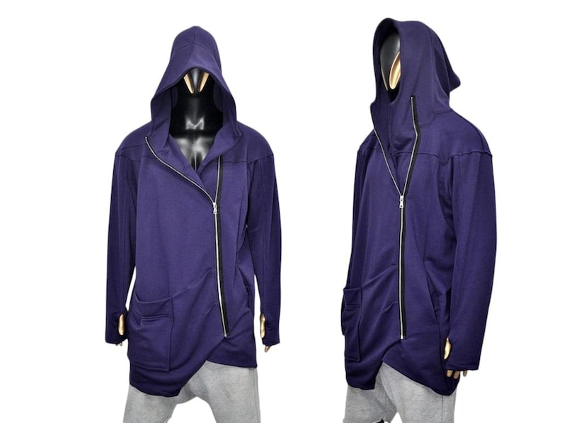 Puede incluir: Chaqueta con capucha morada oscura con cierre de cremallera diagonal y dos bolsillos delanteros. La chaqueta tiene un dise&ntilde;o asim&eacute;trico &uacute;nico y se muestra en un maniqu&iacute;. Las mangas son largas y la capucha es grande.