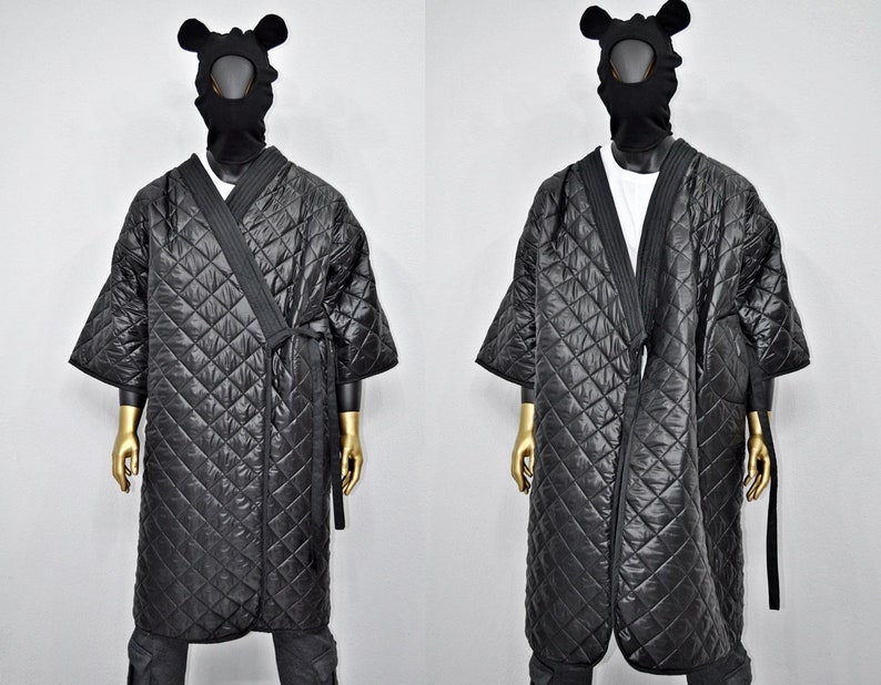 May include: Black quilted robe with a long, wrap-around design and a tie closure. The robe has a diamond-shaped quilted pattern and is made of a soft, comfortable fabric.