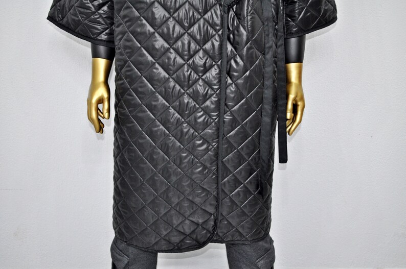 May include: A black quilted robe with a long, black sash. The robe has a diamond pattern and is made of a soft, comfortable material.