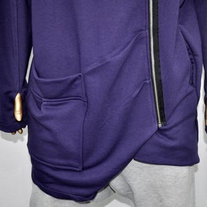 Puede incluir: Una sudadera con capucha de color p&uacute;rpura oscuro con una cremallera diagonal y dos bolsillos delanteros. Las mangas tienen agujeros para los pulgares. La sudadera con capucha est&aacute; hecha de un material suave y c&oacute;modo.