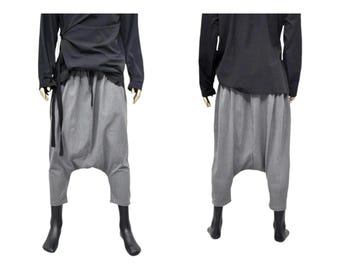 May include: Gray, loose-fitting pants with a drawstring waist and a wide leg. The pants are made of a soft, comfortable fabric and have a relaxed fit.