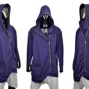 Puede incluir: Chaqueta con capucha azul oscuro con cierre de cremallera diagonal y dos bolsillos delanteros. La chaqueta tiene un dise&ntilde;o asim&eacute;trico &uacute;nico y se muestra en un maniqu&iacute;. La chaqueta es larga y tiene agujeros para los pulgares.