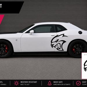 May include: A black Hellcat cat vinyl decal measuring 27 inches by 27 inches. The decal features a stylized cat head graphic with sharp teeth and aggressive features, shown applied to the side of a white car and as a separate graphic.