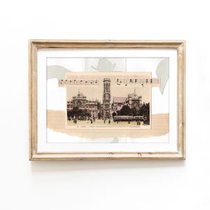 Könnte beinhalten: Eine gerahmte Collage mit einer alten Postkarte der Kirche Saint-Germain-l'Auxerrois in Paris, überlagert mit Streifen von Notenblättern und linierten Papierstücken. Das Kunstwerk befindet sich in einem hellen Holzrahmen mit weißem Passepartout.