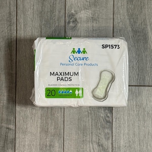 May include: A packet of Secure Maximum Pads for bladder control protection. The white packet features the brand name and product details in blue and green. The packet contains 20 pads and has an image of a pad on the front.
