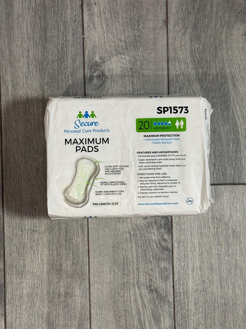 May include: A packet of Secure Maximum Pads, containing 20 individually wrapped pads with a plastic backing. The packaging shows product information, including a pad length of 34.93 cm, and usage instructions.