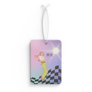 May include: Rectangular air freshener with a cartoon illustration of a woman in a white crop top and green pants. The background has a checkered flag design and a sun. The Japanese characters "漂流" are also present.