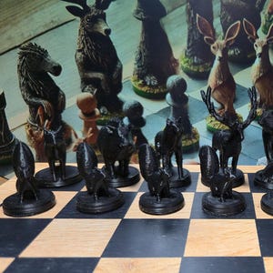 K&ouml;nnte beinhalten: Ein einzigartiges Schachspiel mit Tierfiguren. Die schwarzen Figuren sind schwarze Tierfiguren, w&auml;hrend die gegnerischen Figuren braun und beige sind. Das Set wird auf einem klassischen schwarz-wei&szlig;en Schachbrett pr&auml;sentiert.