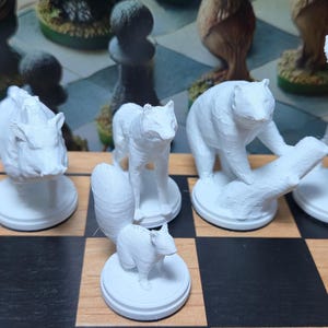 K&ouml;nnte beinhalten: Wei&szlig;es Schachspiel mit Tierfiguren. Enth&auml;lt ein Nashorn, einen Fuchs, einen B&auml;ren und einen Hirsch. Die Figuren stehen auf einem schwarz-wei&szlig;en Schachbrett. Das Set ist mit detaillierten Tierfiguren gestaltet.