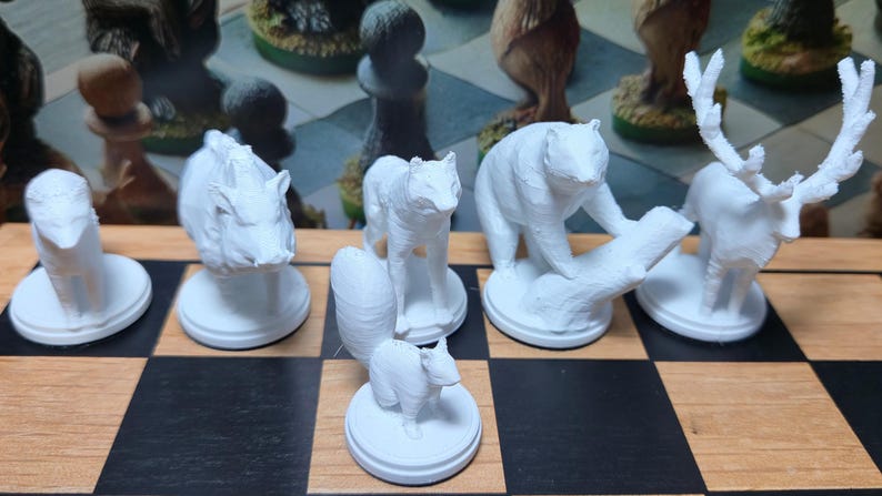 K&ouml;nnte beinhalten: Wei&szlig;es Schachspiel mit Tierfiguren. Enth&auml;lt ein Nashorn, einen Fuchs, einen B&auml;ren und einen Hirsch. Die Figuren stehen auf einem schwarz-wei&szlig;en Schachbrett. Das Set ist mit detaillierten Tierfiguren gestaltet.