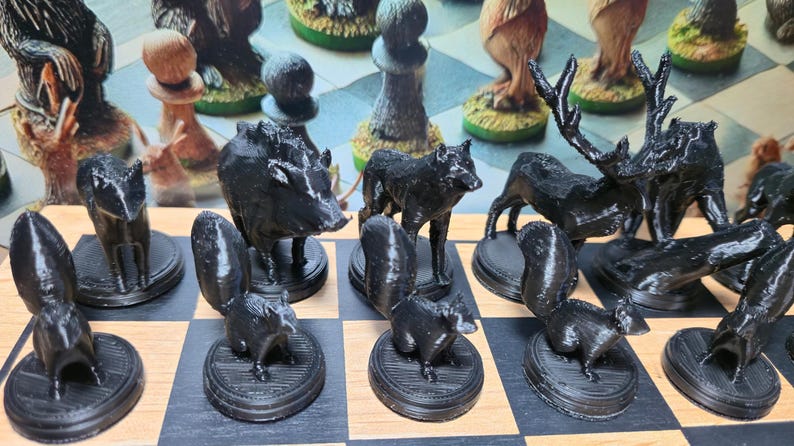 K&ouml;nnte beinhalten: Ein schwarzes Schachspiel mit Tierfiguren. Das Set enth&auml;lt Figuren in Form eines Eichh&ouml;rnchens, Wolfs, Wildschweins und Hirsches, die auf einem Schachbrett angeordnet sind. Die Figuren sind detailliert und heben sich von den hellen und dunklen Feldern ab.