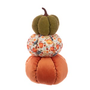 May include: A decorative stack of three plush pumpkins in autumnal colours. The bottom pumpkin is orange corduroy, the middle one is patterned with fall leaves and pumpkins, and the top is green knit.